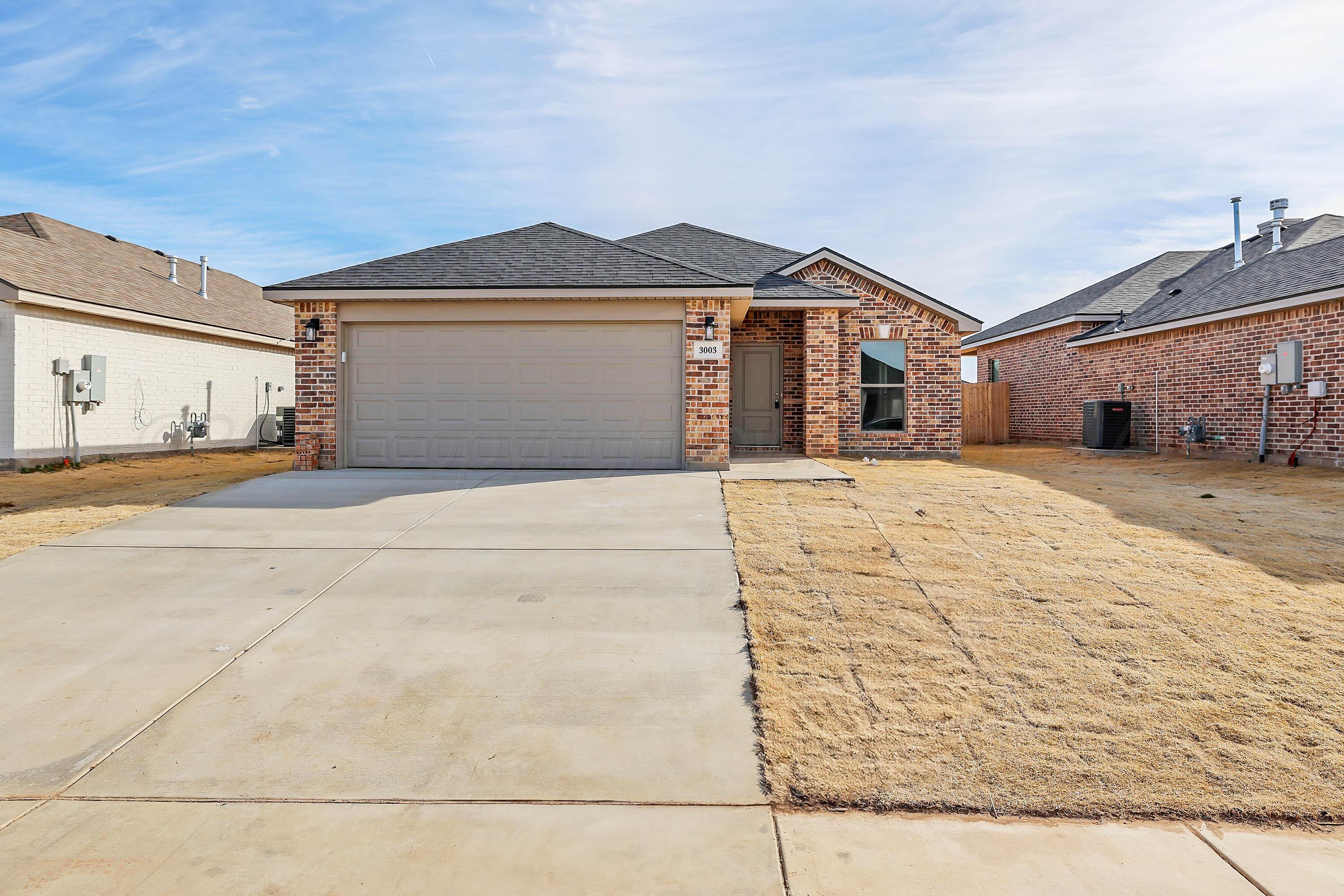 3003 Swenson Street Amarillo, TX 79124 - Photo 1 of 23 a front view of a house with a yard and garage