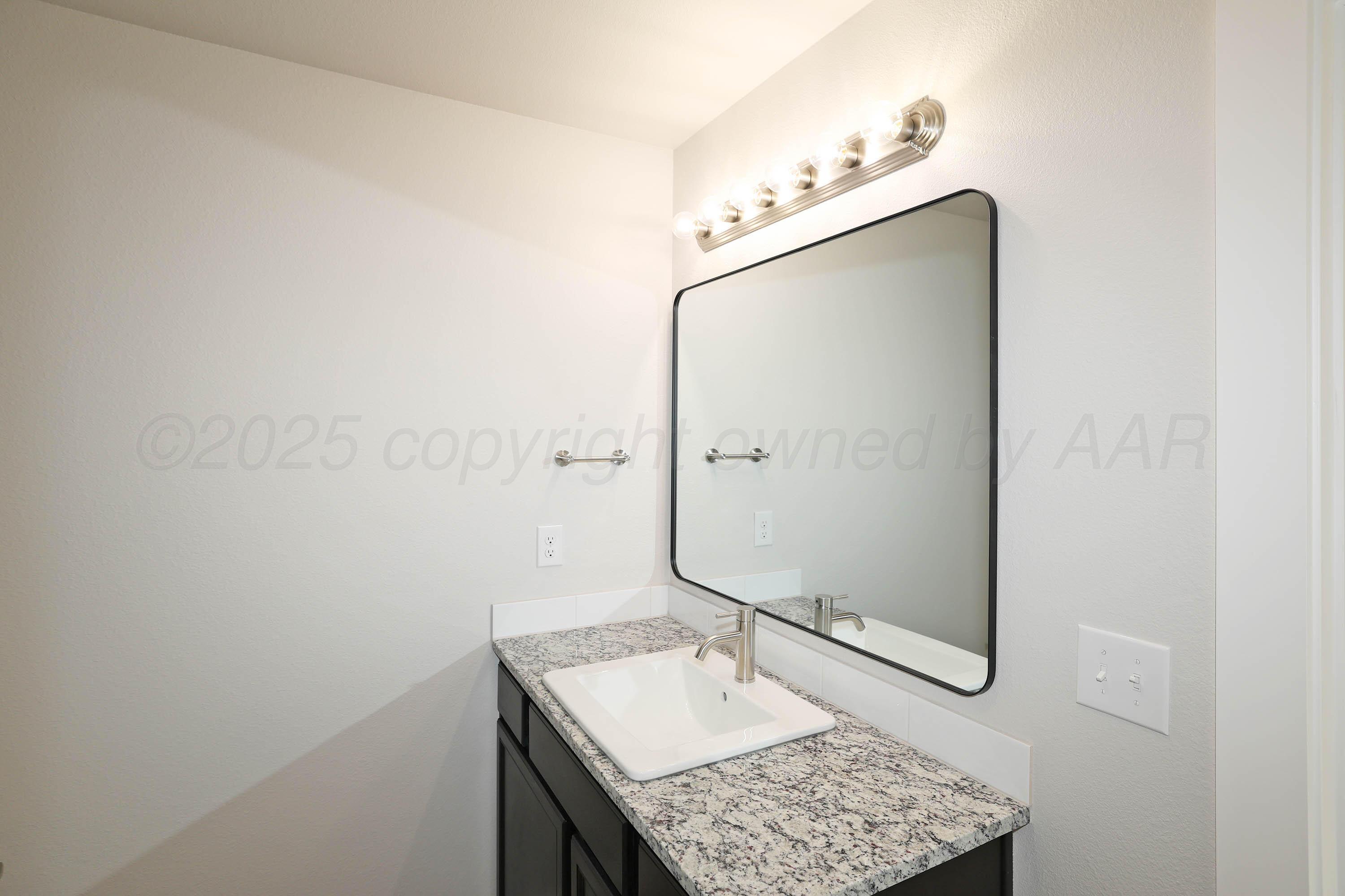 3003 Swenson Street Amarillo, TX 79124 - Photo 15 of 23 a bathroom with a granite countertop sink mirror and vanity