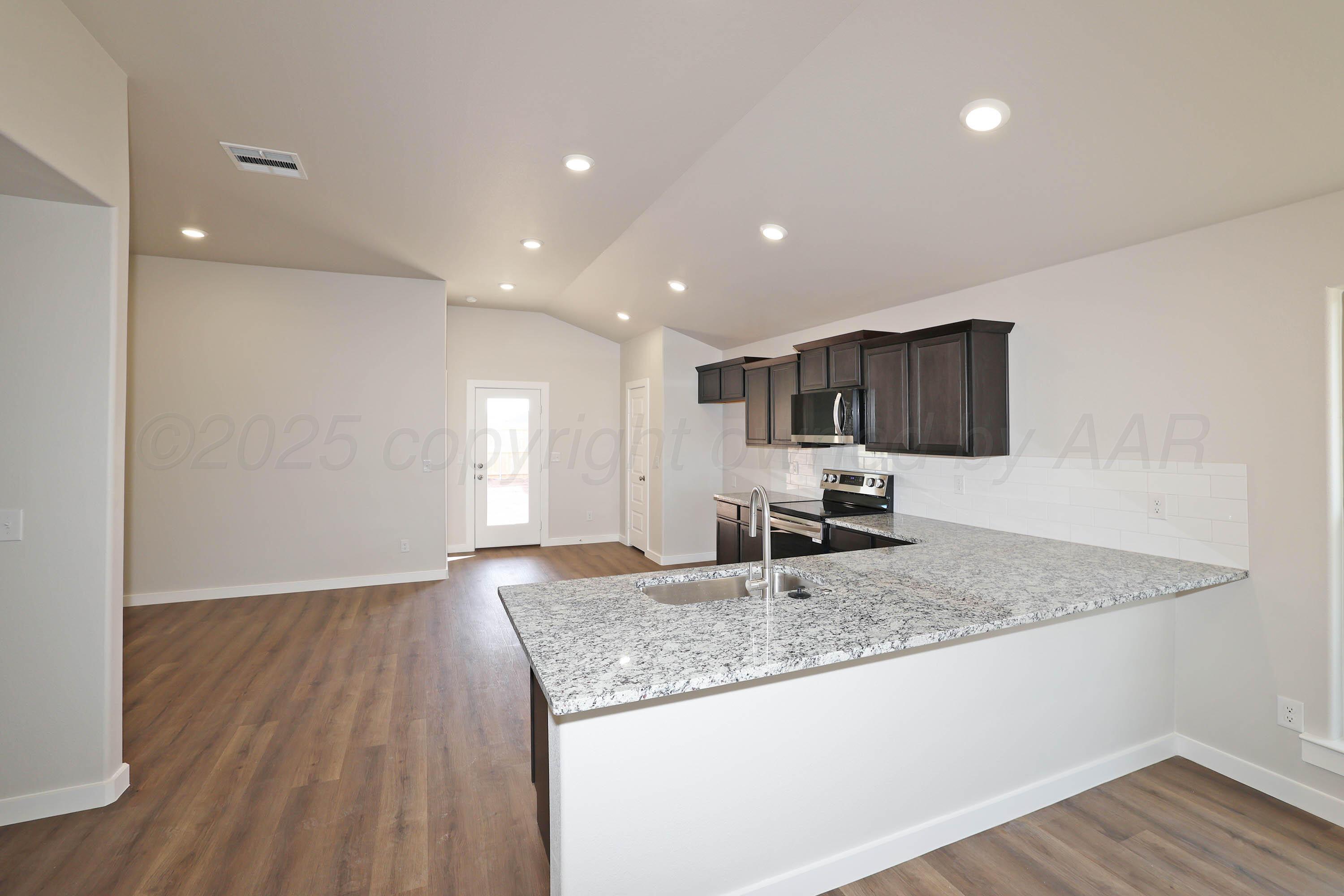 3003 Swenson Street Amarillo, TX 79124 - Photo 8 of 23 a view of kitchen with granite countertop sink and refrigerator