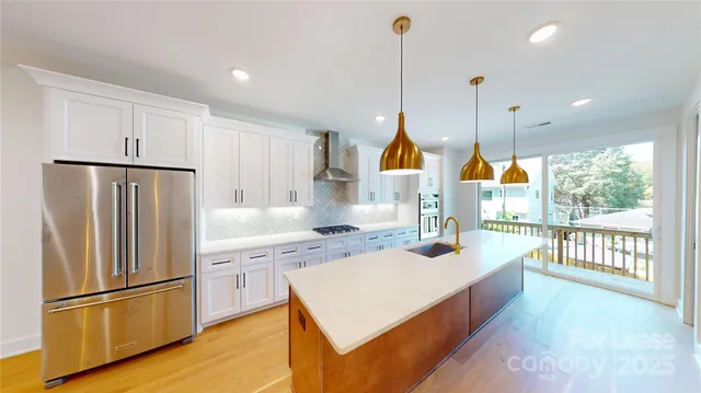 a kitchen with a refrigerator a sink and wooden floor