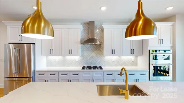 a kitchen with stainless steel appliances granite countertop a sink a stove and a refrigerator