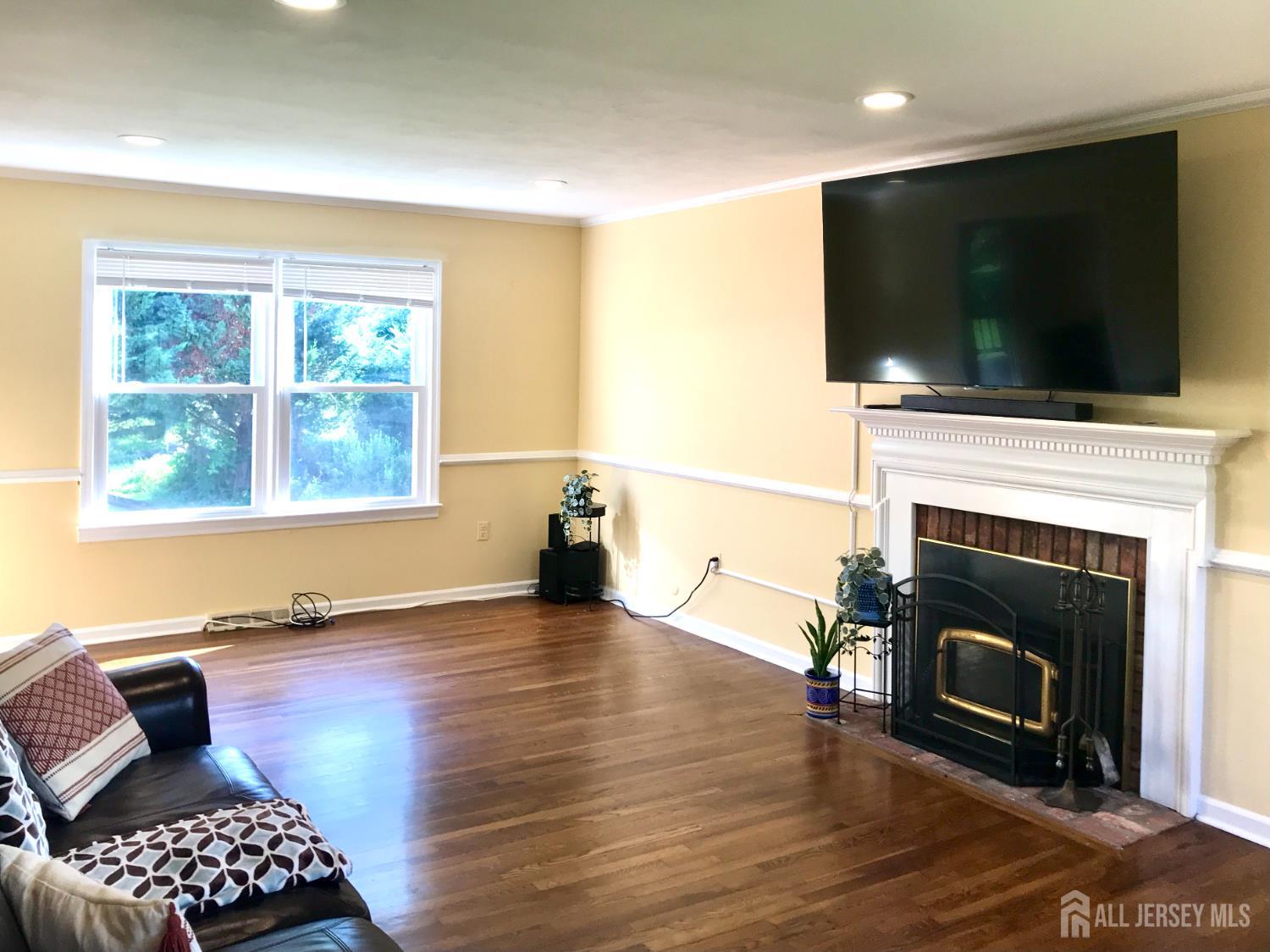 39 Taylor Road Monmouth Junction, NJ 08852 - Photo 11 of 36 a living room with furniture a flat screen tv and a fireplace