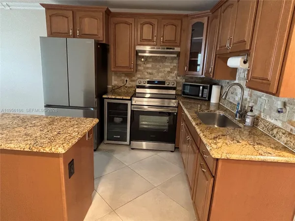 a kitchen with kitchen island granite countertop a stove and a sink