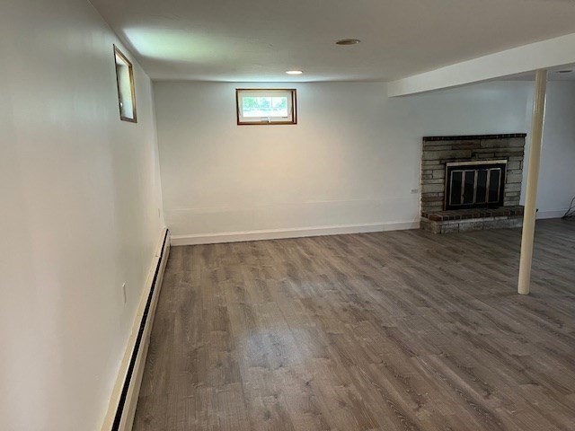404 Cedar Street Hanover, MA 02339 - Photo 10 of 17 an empty room with wooden floor and fireplace
