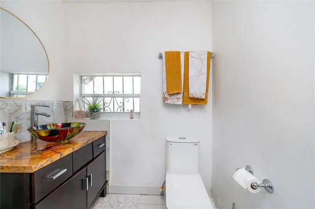 a bathroom with a sink mirror and a window