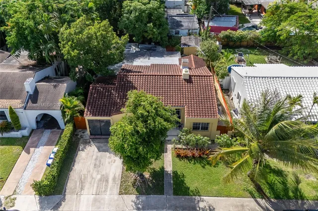 an aerial view of a house with garden space and street view