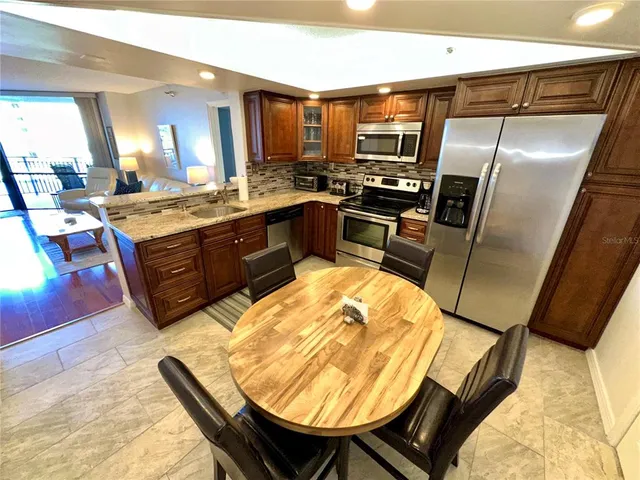 a kitchen with stainless steel appliances granite countertop a refrigerator and a stove