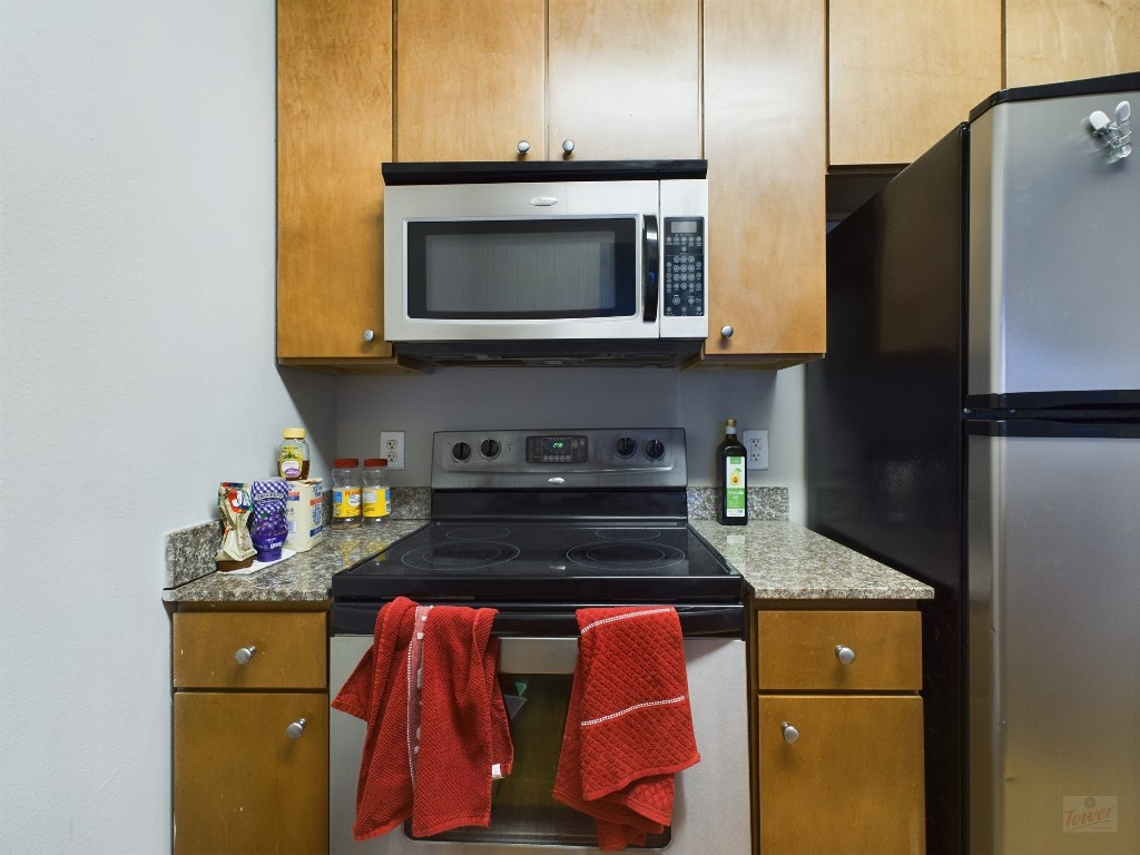 2502 Leon Street, Unit 218 Austin, TX 78705 - Photo 4 of 15 a kitchen with granite countertop stainless steel appliances and wooden cabinets