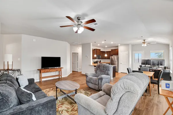 a living room with furniture kitchen view and a flat screen tv