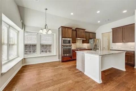 a kitchen with kitchen island a counter top space appliances and a center island