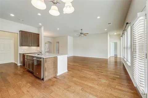 a large kitchen with stainless steel appliances granite countertop a large counter top and a wooden floors
