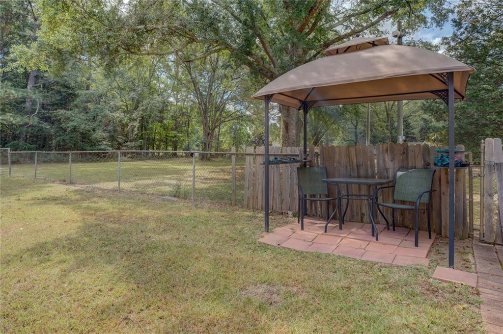 11889 Brown Bridge Road Covington, GA 30016 - Photo 27 of 27 a backyard of a house with table and chairs under an umbrella