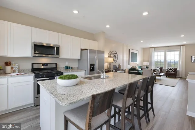 a kitchen with granite countertop a table chairs stove and cabinets