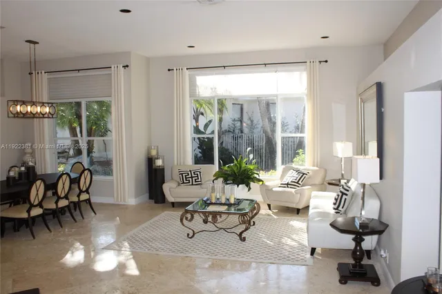 a living room with furniture and floor to ceiling windows
