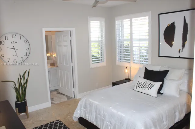 a bedroom with a bed a painting on the wall and a window