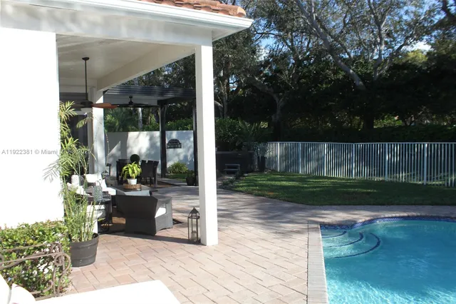 a view of a patio with table and chairs potted plants and floor to ceiling window