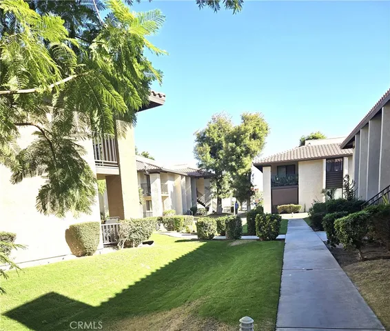a front view of a house with a yard and potted plants