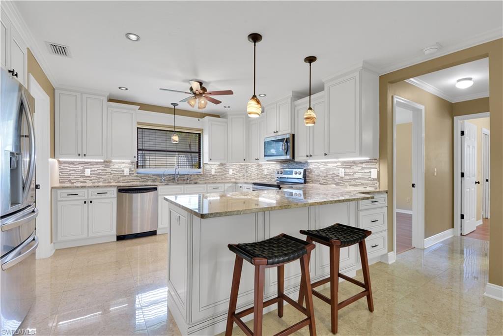 17557 Butler Road Fort Myers, FL 33967 - Photo 6 of 35 a kitchen with kitchen island granite countertop a sink cabinets and stainless steel appliances