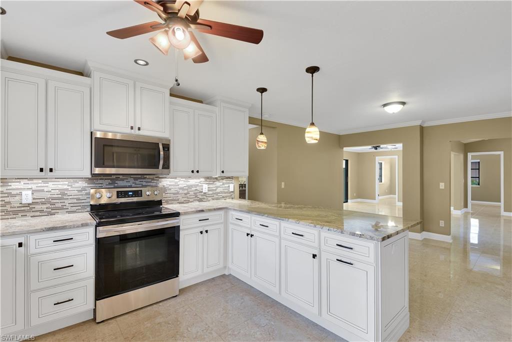 17557 Butler Road Fort Myers, FL 33967 - Photo 7 of 35 a kitchen with white cabinets and appliances