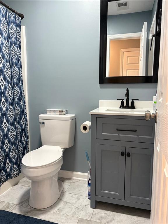 701 Pine Tree Trail, Unit 10E Atlanta, GA 30349 - Photo 12 of 33 a bathroom with a toilet sink and mirror