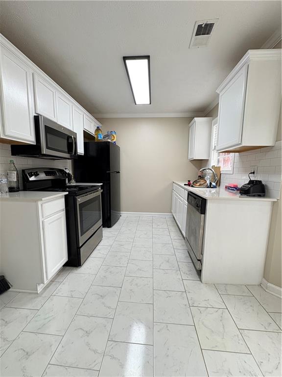 701 Pine Tree Trail, Unit 10E Atlanta, GA 30349 - Photo 15 of 33 a kitchen with stainless steel appliances a sink a stove a microwave a sink a refrigerator and cabinets