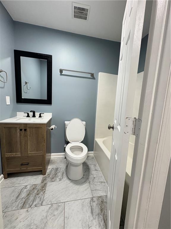 701 Pine Tree Trail, Unit 10E Atlanta, GA 30349 - Photo 26 of 33 a bathroom with a toilet sink and mirror