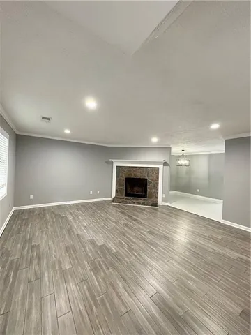 an empty room with wooden floor and fireplace