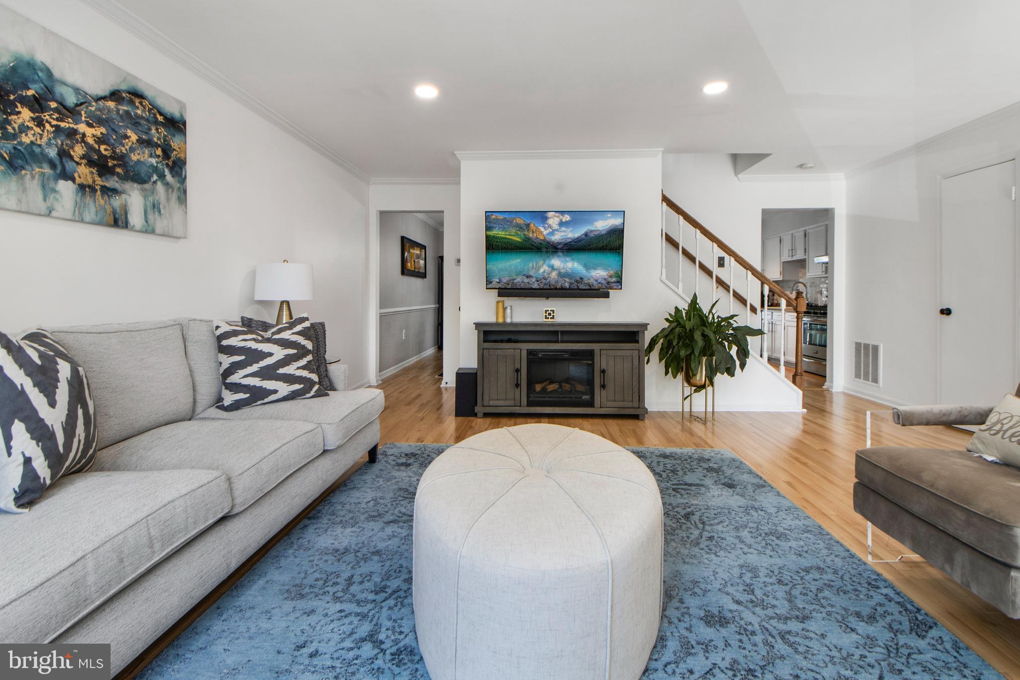 14432 Bakersfield Court Silver Spring, MD 20906 - Photo 11 of 60 a living room with furniture a flat screen tv and a fireplace