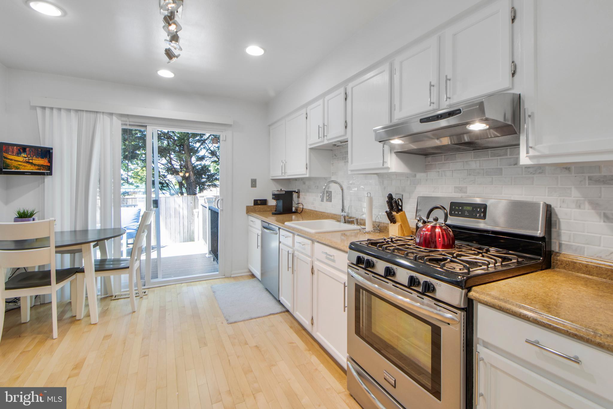 14432 Bakersfield Court Silver Spring, MD 20906 - Photo 18 of 60 a kitchen with stainless steel appliances granite countertop a stove a sink dishwasher and cabinets with wooden floor