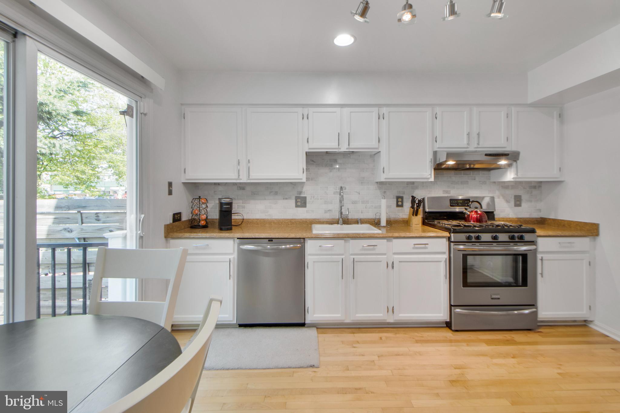 14432 Bakersfield Court Silver Spring, MD 20906 - Photo 19 of 60 a kitchen with stainless steel appliances granite countertop a stove a sink and a refrigerator
