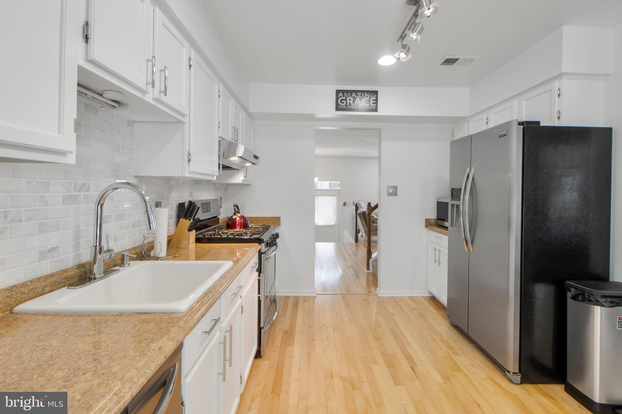 14432 Bakersfield Court Silver Spring, MD 20906 - Photo 20 of 60 a kitchen with stainless steel appliances a sink stove refrigerator and cabinets