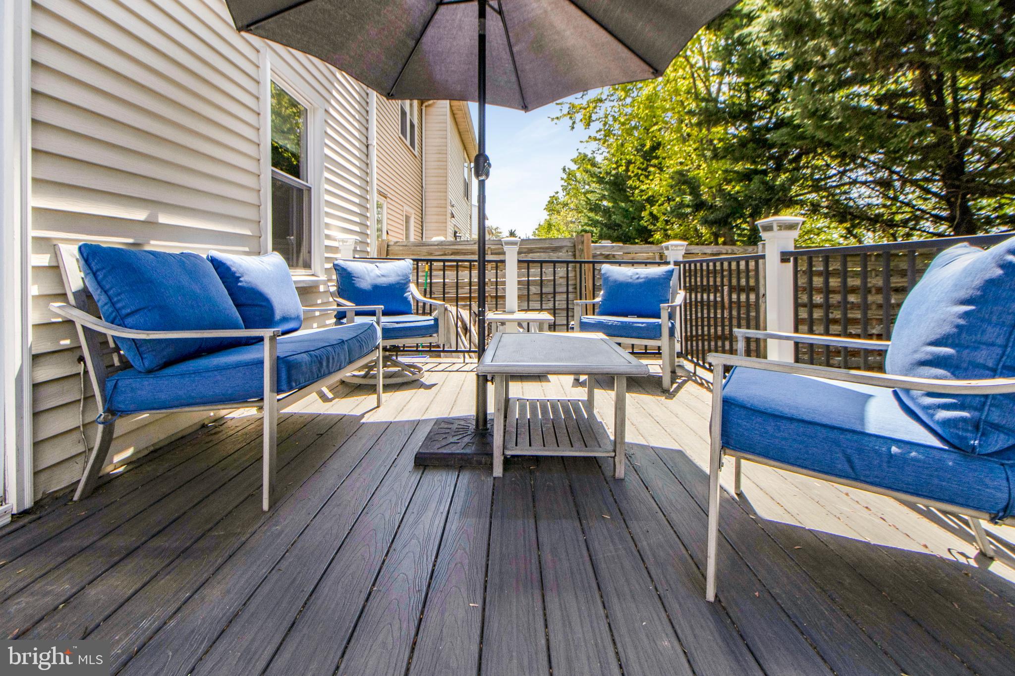 14432 Bakersfield Court Silver Spring, MD 20906 - Photo 59 of 60 a view of a roof deck with table and chairs under an umbrella with wooden floor