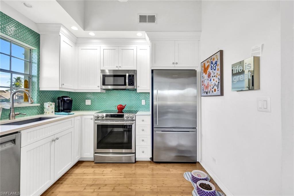 14985 Rivers Edge Court, Unit 236 Fort Myers, FL 33908 - Photo 12 of 33 a kitchen with stainless steel appliances a refrigerator sink and microwave