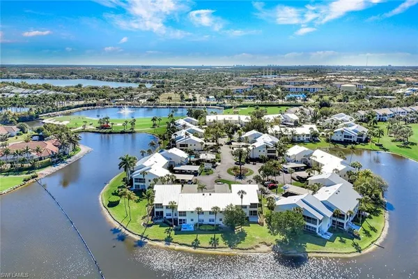 an aerial view of ocean and residential houses with outdoor space