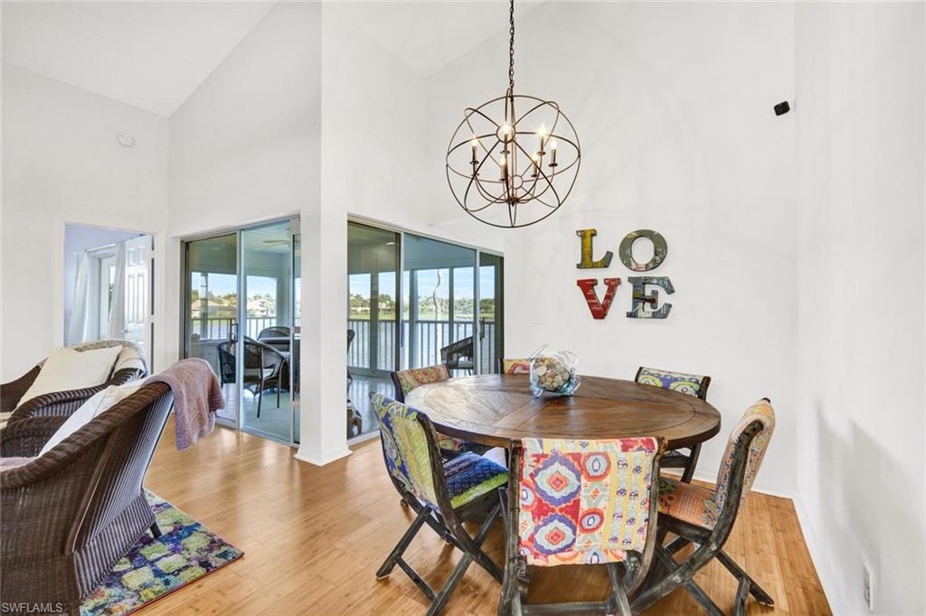 14985 Rivers Edge Court, Unit 236 Fort Myers, FL 33908 - Photo 10 of 33 a view of a dining room with furniture wooden floor and a chandelier