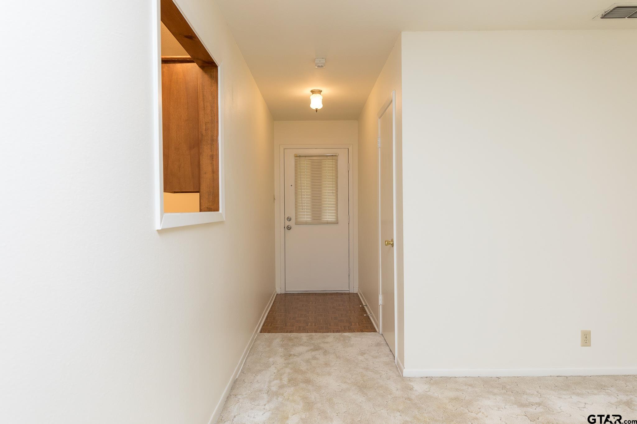 1707 Sampson Drive Tyler, TX 75701 - Photo 8 of 24 a view of a hallway with wooden floor and a bathroom