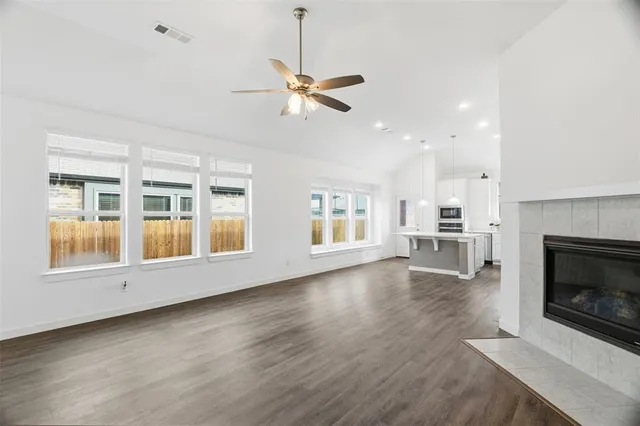 a view of empty room with wooden floor and fireplace
