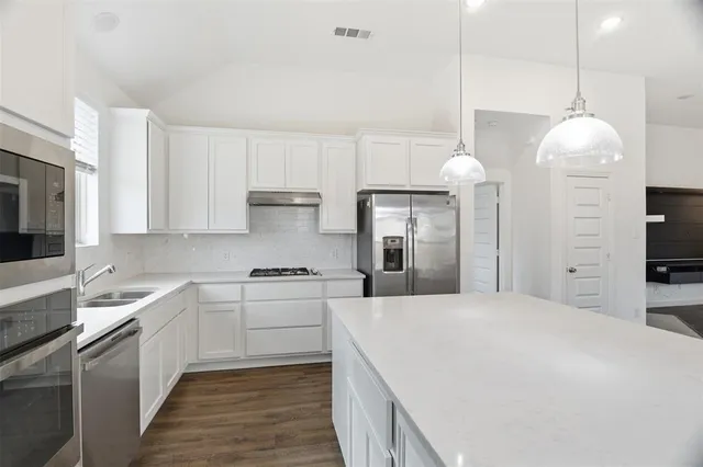 a large kitchen with kitchen island a sink stainless steel appliances and cabinets