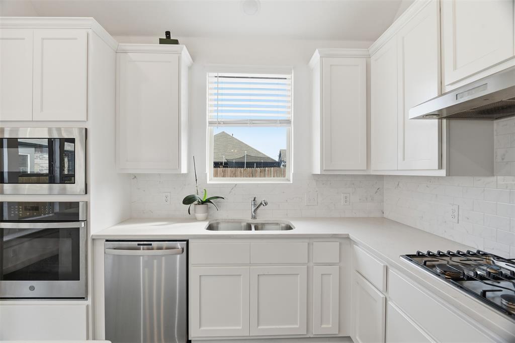 3910 Rochelle Lane Crandall, TX 75114 - Photo 18 of 32 a kitchen with white cabinets and a stove