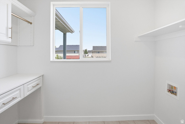 3636 West 910 South Syracuse, UT 84075 - Photo 25 of 70 Functional utility space featuring a built-in white desk, upper cabinetry with hanging rod, and wall-mounted shelving