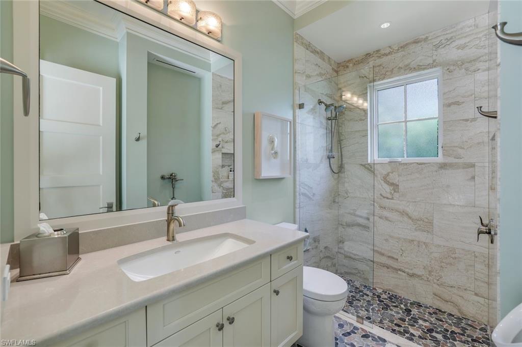 350 Springline Drive Naples, FL 34102 - Photo 22 of 33 Bathroom featuring a shower stall, vanity, and ornamental molding