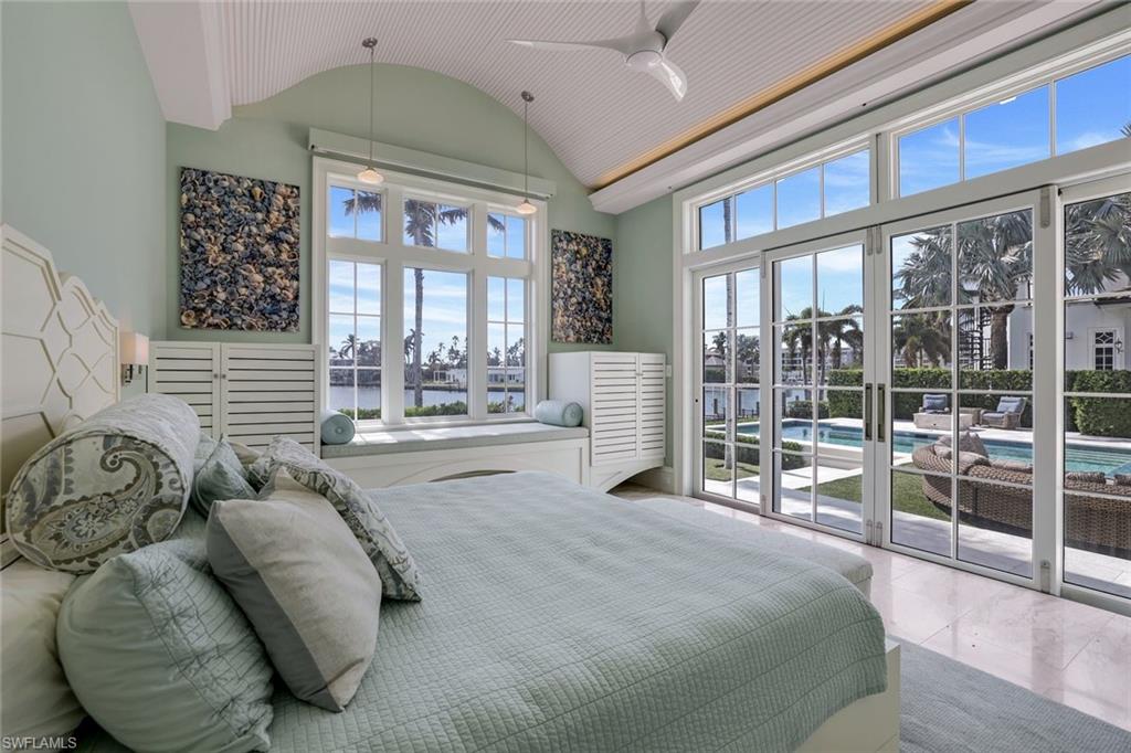 350 Springline Drive Naples, FL 34102 - Photo 23 of 33 Bedroom featuring access to exterior, ceiling fan, vaulted ceiling, and a water view