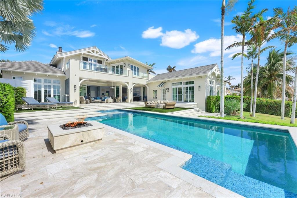 350 Springline Drive Naples, FL 34102 - Photo 25 of 33 Cabana featuring an outdoor living space with a fire pit, a balcony, a patio area, an outdoor pool, and a chimney