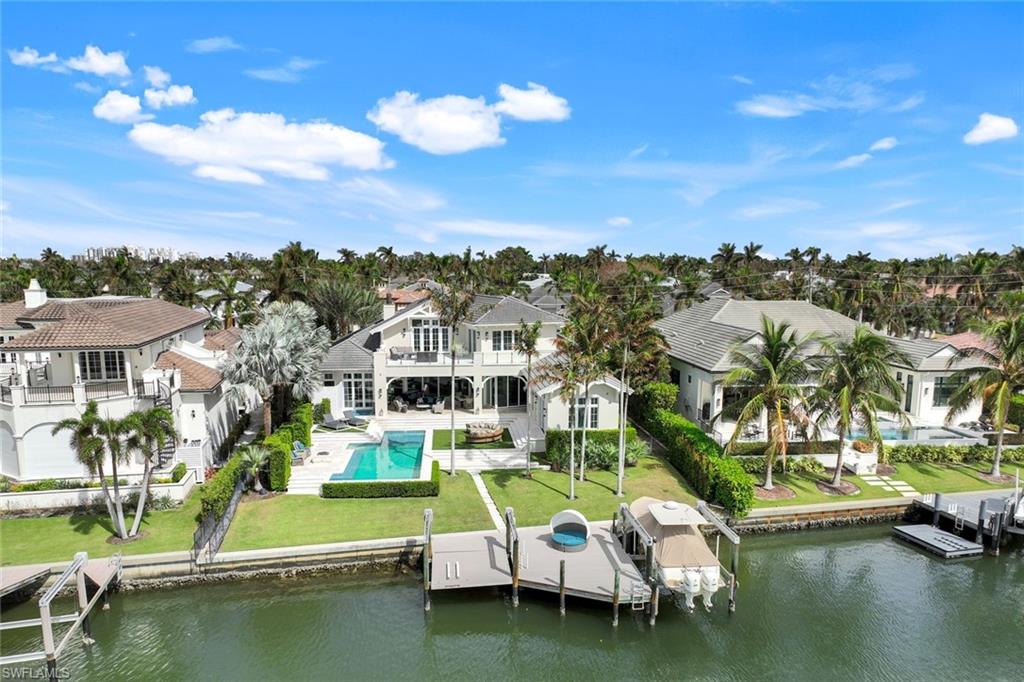 350 Springline Drive Naples, FL 34102 - Photo 29 of 33 Rear view of house with a yard, a patio area, boat lift, an outdoor pool, and a water view