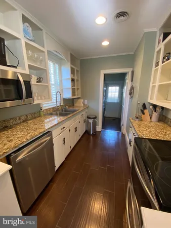 a kitchen with stainless steel appliances granite countertop a sink stove and cabinets