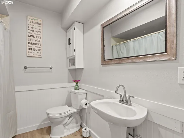a bathroom with a toilet sink and mirror