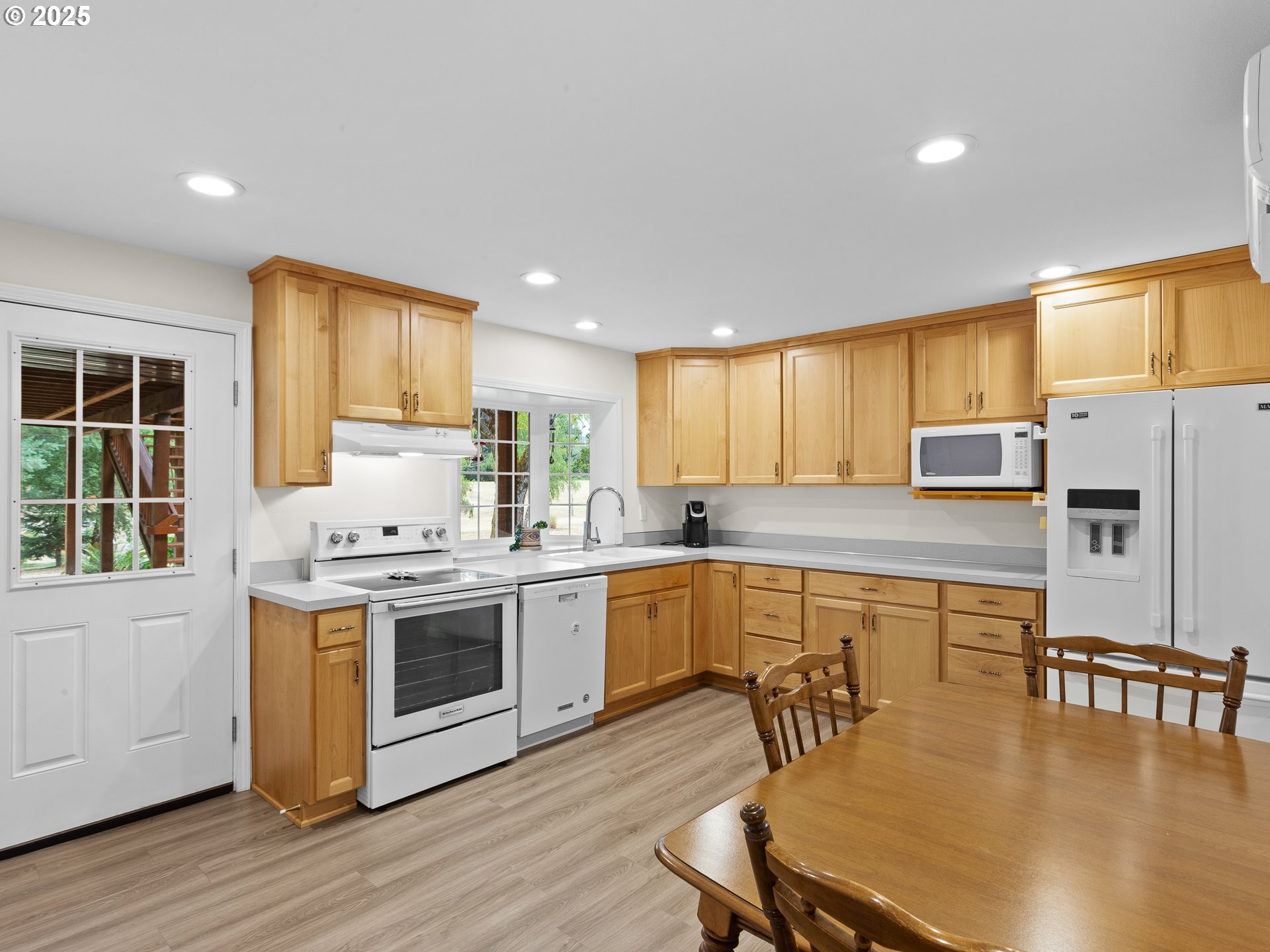 34603 Southeast Jarl Road Boring, OR 97009 - Photo 26 of 48 a kitchen with stainless steel appliances granite countertop a stove top oven a sink dishwasher a dining table and chairs with wooden floor