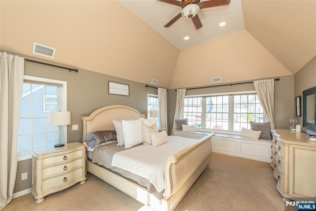 18 Stonycroft Road Wayne, NJ 07470 - Photo 16 of 40 a large bed sitting in a room next to a lamp with a chandelier and a flat tv screen