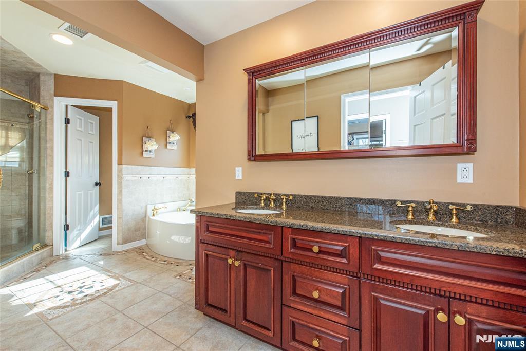 18 Stonycroft Road Wayne, NJ 07470 - Photo 19 of 40 a spacious bathroom with a granite countertop sink and a mirror