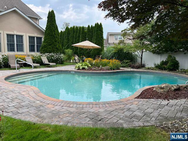 18 Stonycroft Road Wayne, NJ 07470 - Photo 34 of 40 a view of a swimming pool with lawn chairs under an umbrella